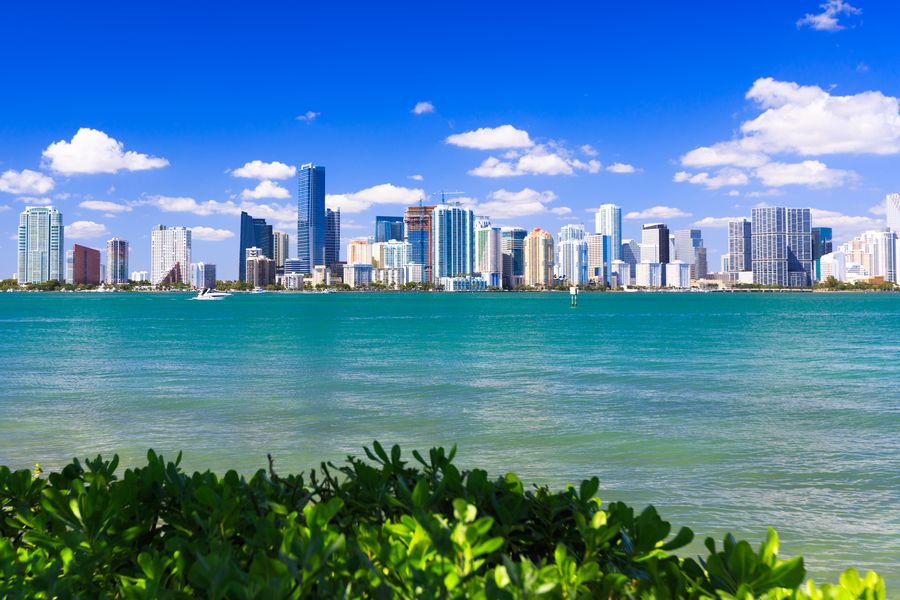 Downtown Miami skyline across turquoise Biscayne Bay water under a bright blue sky