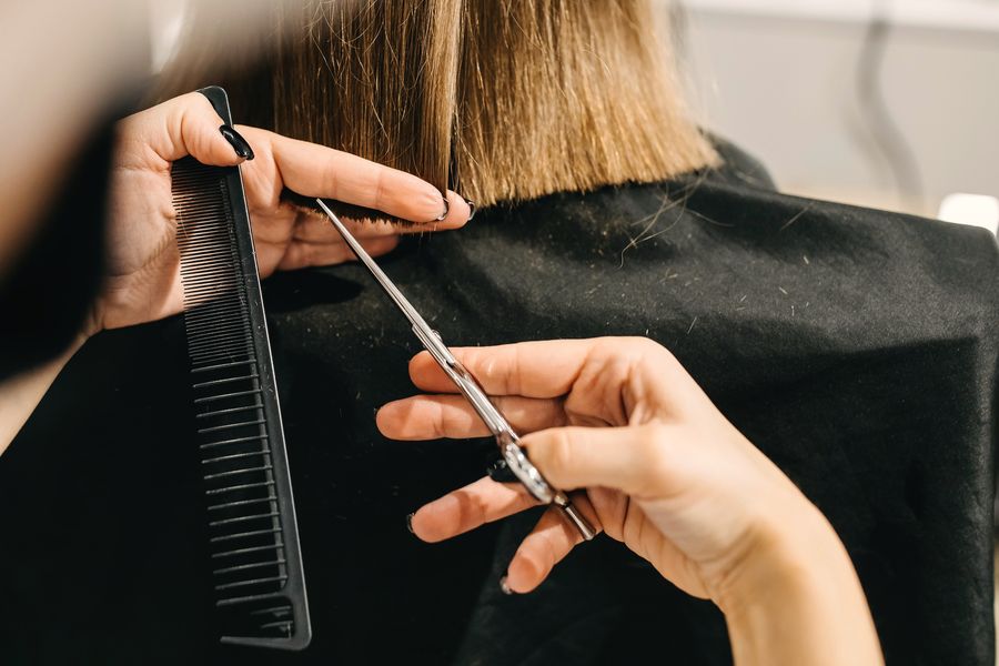 Close-up of a stylist cutting a blunt bob with shears and a comb